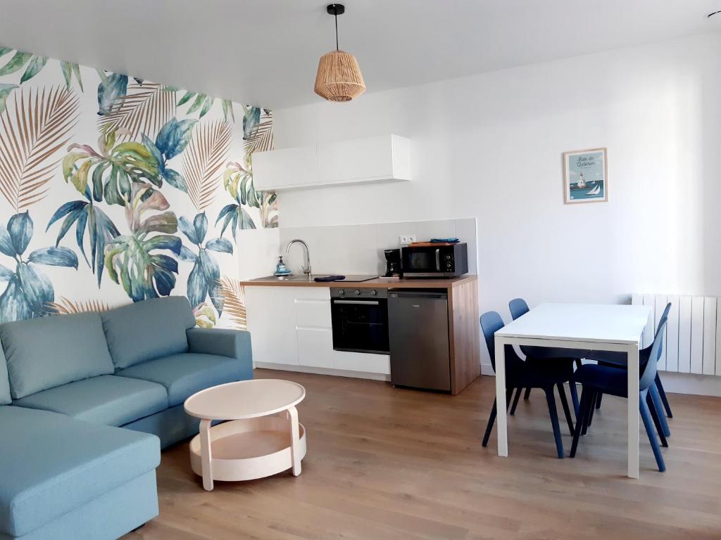 un salon avec un canapé bleu et une table dans l'établissement Le Garde-Côtes, à Étel