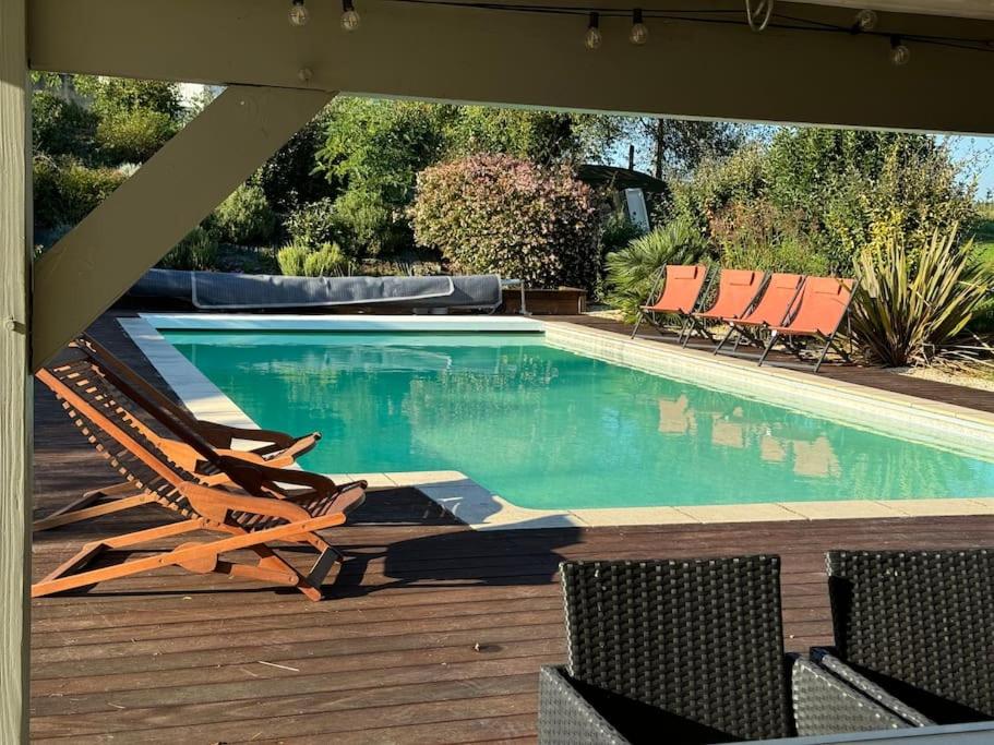 a swimming pool with two lawn chairs and a pool slide at Maison Bordeaux Saint Émilion in Beychac-et-Caillau