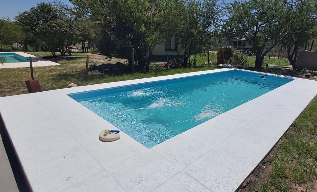 una piscina en un patio al lado de una casa en Monchos House, en Merlo