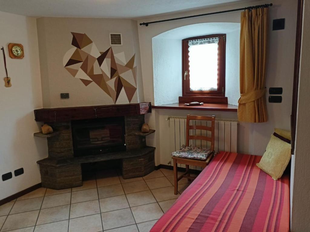 salon z kominkiem i krzesłem w obiekcie Casa D'antan Gressan w Aoście