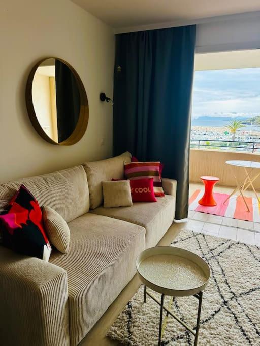 un salon avec un canapé et un miroir dans l'établissement Face à la mer, coucher de soleil, à Six-Fours-les-Plages