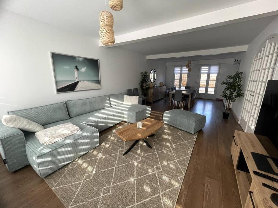 un salon avec un canapé et une table dans l'établissement Belle maison de plage pour familles, à Dunkerque