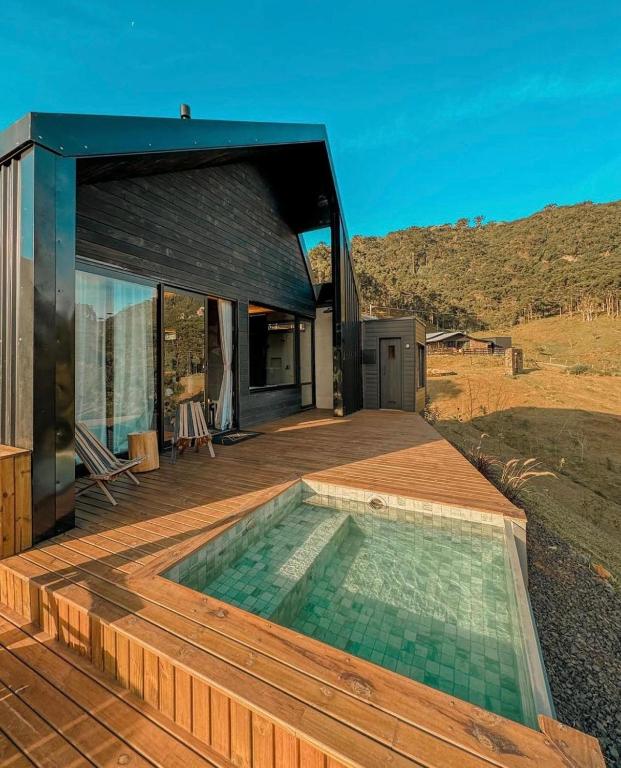 a house with a swimming pool on a wooden deck at Vale Sagrado in Urubici