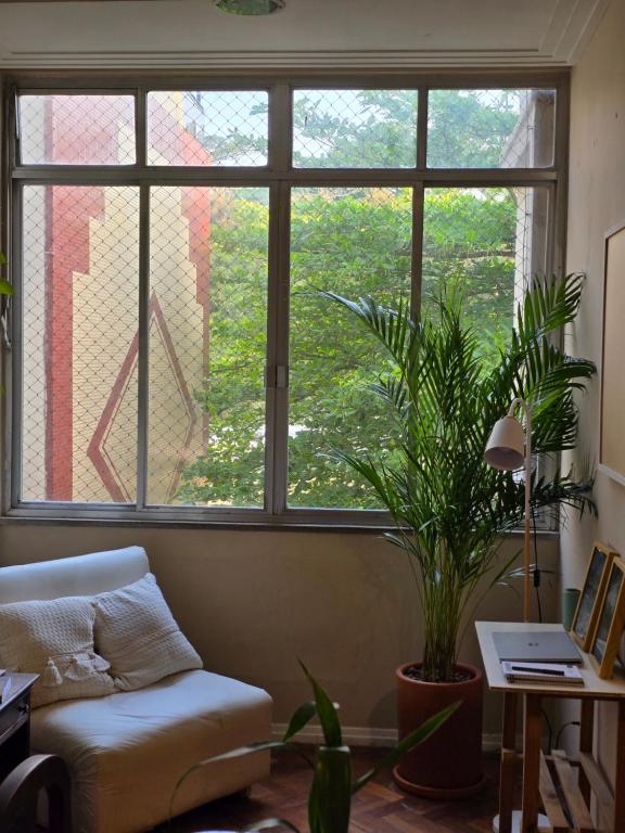 a living room with a couch and a large window at apartment cool & seafront Arpoador in Rio de Janeiro