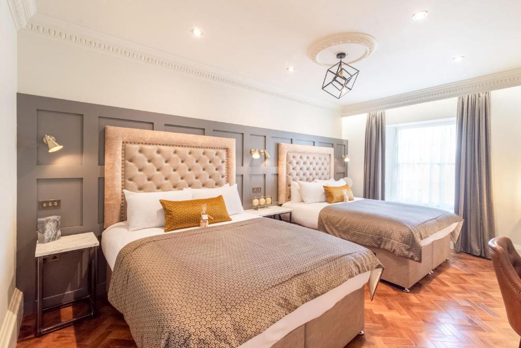 a bedroom with two beds and a large window at King Street Aparthotel in Stirling