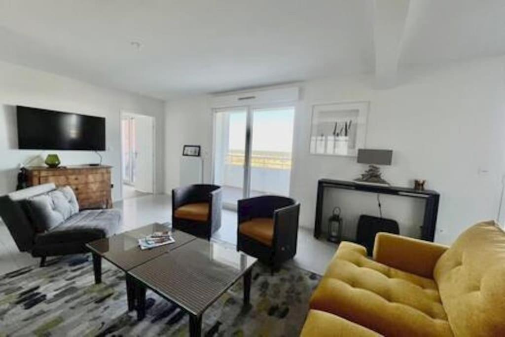 un salon avec un canapé et une table dans l'établissement Le Panoramique vue mer, à Dunkerque