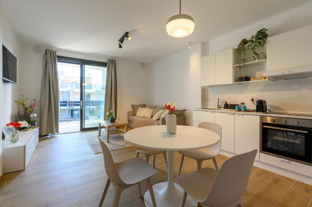 フィウミチーノにあるTiber Terrace Retreat - Free Parking, Wi-Fi & Netflixのテーブルと椅子のあるキッチンとリビングルーム