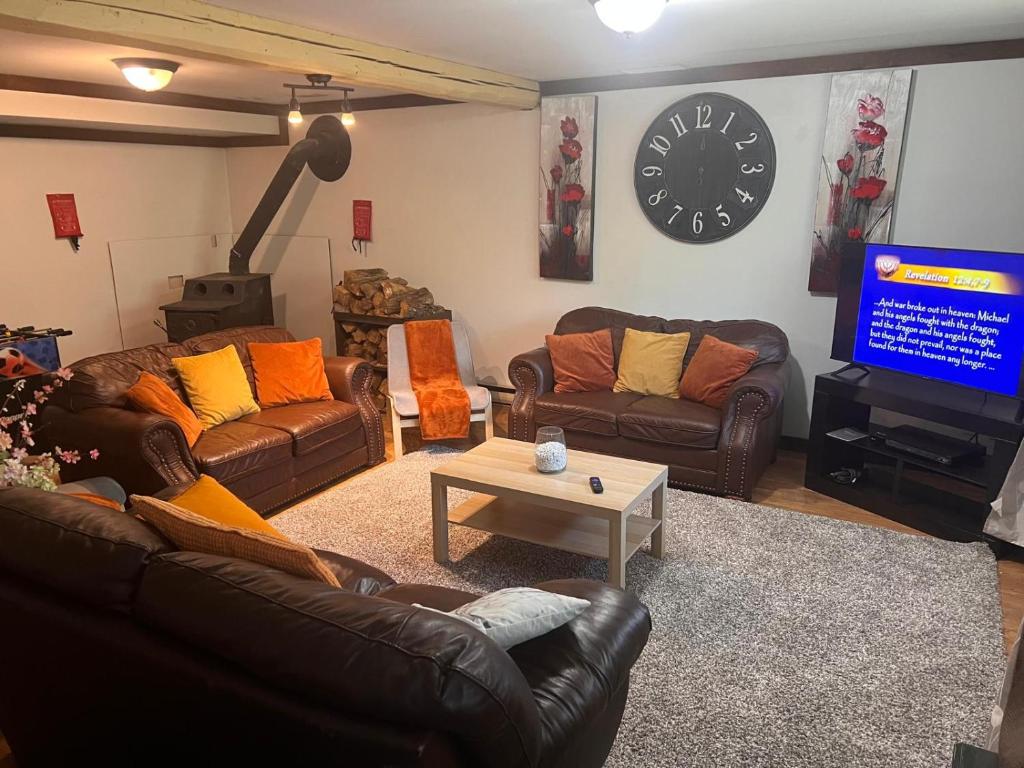 a living room with couches and a flat screen tv at Maison de vacances in Rivière-Rouge