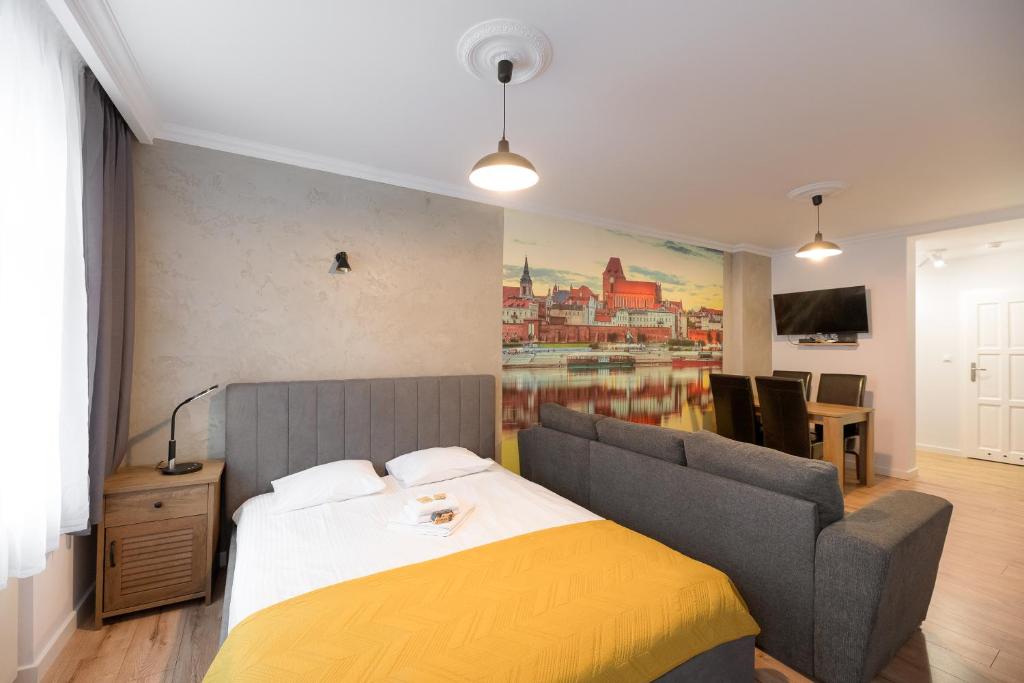 una camera con un letto, un divano e un quadro di Sunset Apartaments - Sunflower a Toruń