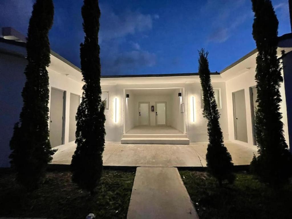 a white house with trees in front of it at Casa Canal in North Miami Beach