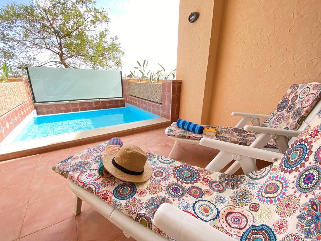 a patio with two chairs and a swimming pool at Lujoso Apartamento en el tranquilo Resort Hacienda del Alamo in Murcia