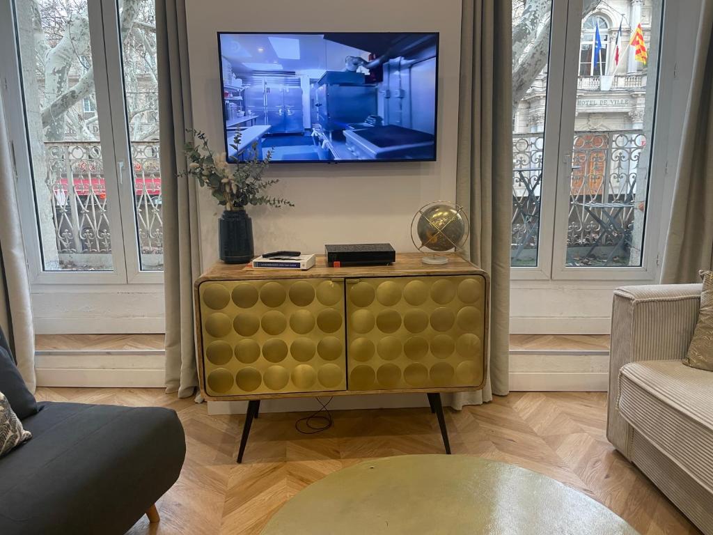 un salon avec une télévision et un canapé dans l'établissement Studi Ô place de L HORLOGE, à Avignon