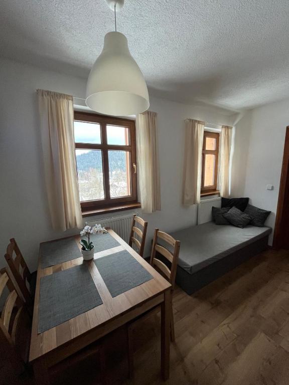 a living room with a dining table and a bed at Chalupa u Josefa in Josefuv dul