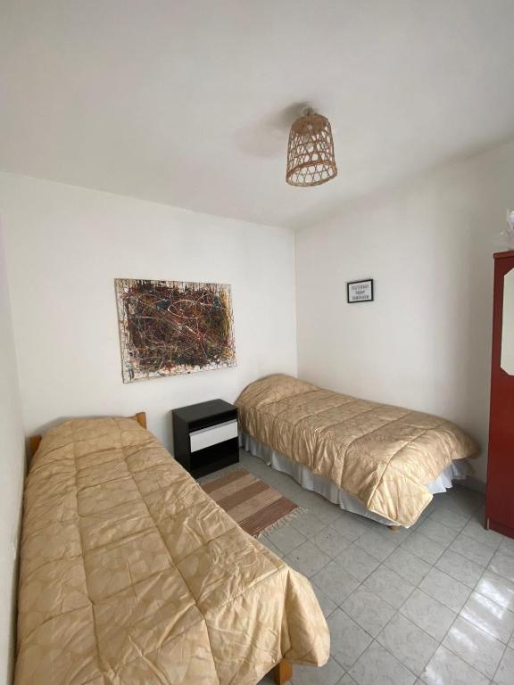 a bedroom with two beds and a painting on the wall at Los Nogales I in Neuquén