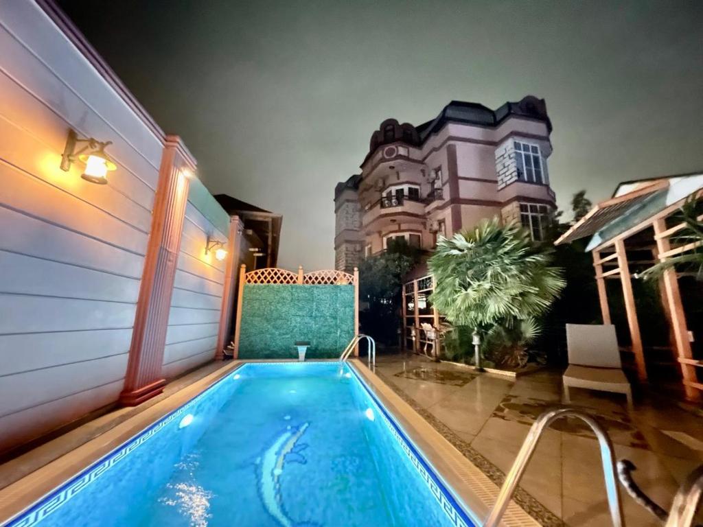 a swimming pool in front of a house at Badamdar villa with pool and sauna in Baku
