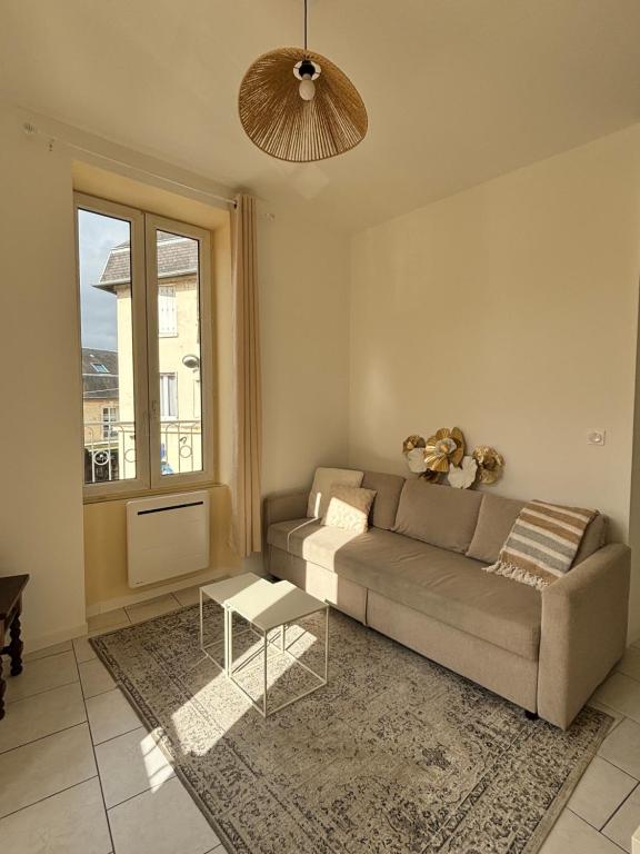 un soggiorno con un divano e un tavolo di Appartement au coeur de la ville a La Ferté-Bernard