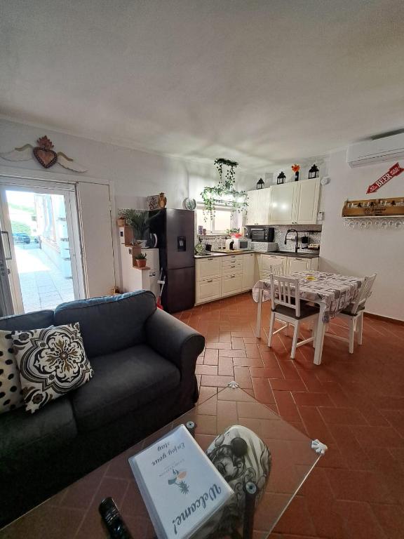 a living room with a couch and a table and a kitchen at IlMareaDuePassi Guest House in Rosignano Solvay