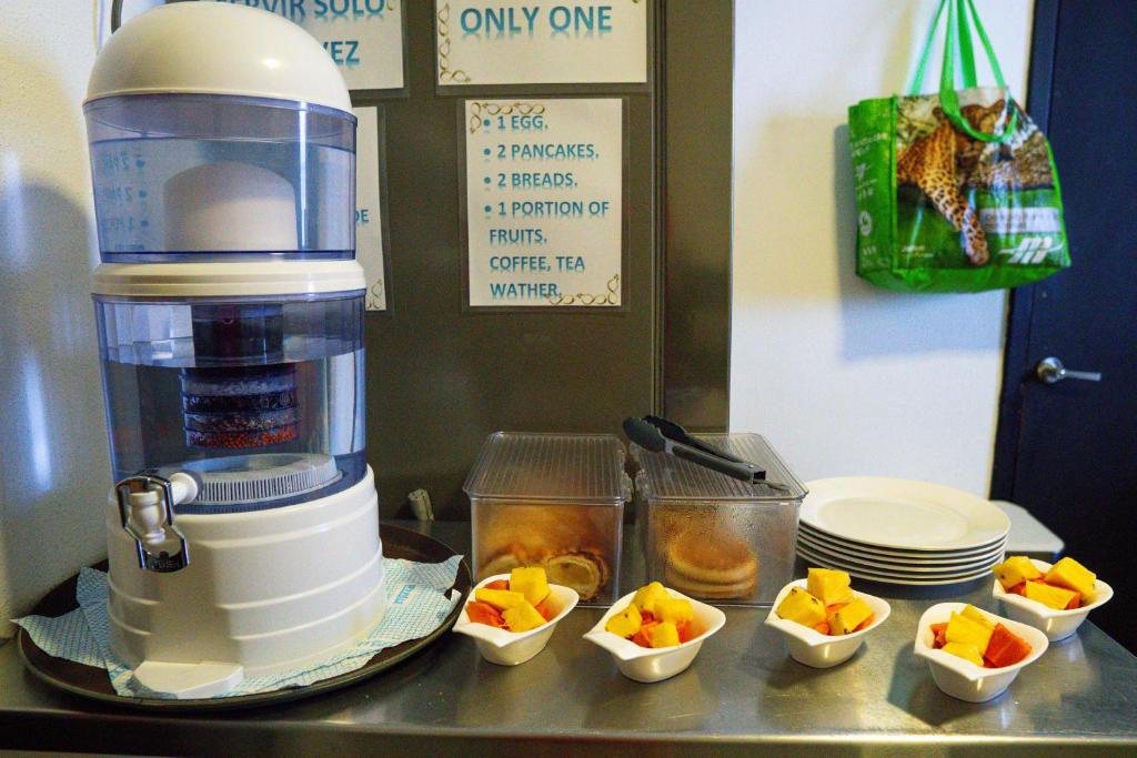 a coffee maker sitting on a counter with bowls of fruit at Eden`s Garden Hostel in Panama City