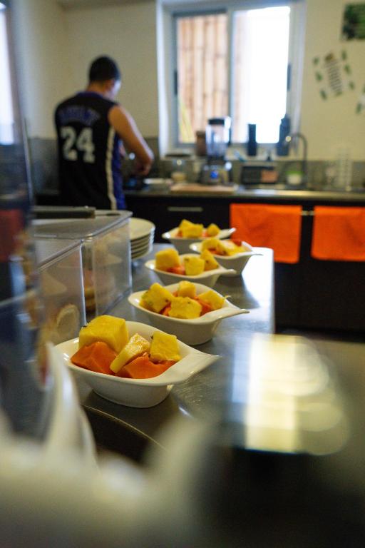 a row of bowls of food on a counter in a kitchen at Eden`s Garden Hostel in Panama City
