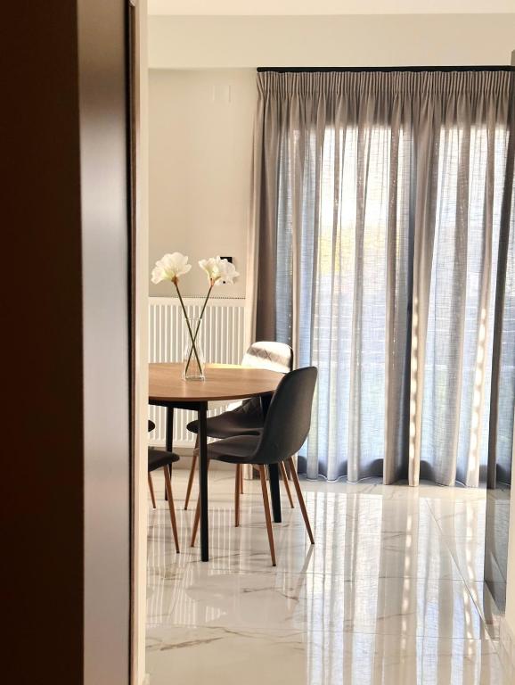 a dining room table with a vase of flowers on it at DK Luxury Living in Ioannina