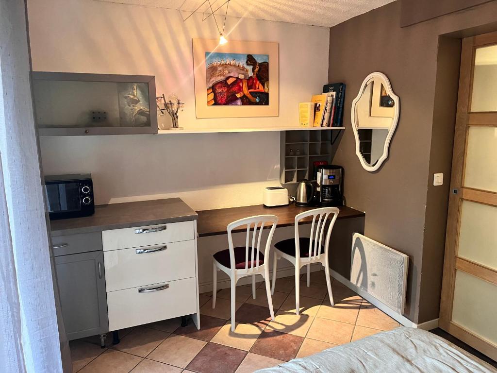 a small kitchen with a desk and two chairs at Chambre aménagée à Quintal in Quintal