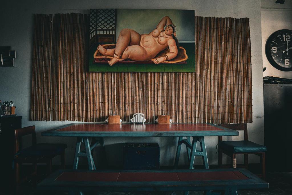 a table in a room with a painting on the wall at Eden`s Garden Hostel in Panama City