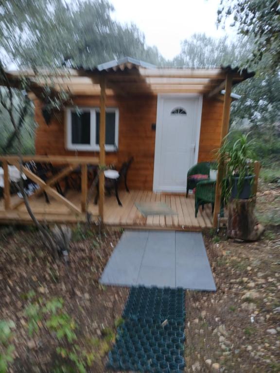 a log cabin with a porch and a white door at Chez Eve 2 in Nîmes