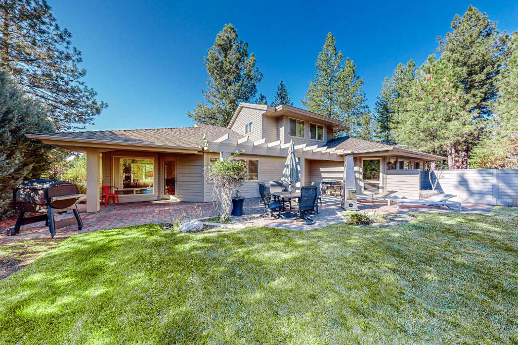 a house with a grill in the yard at Dogleg Retreat in Sunriver