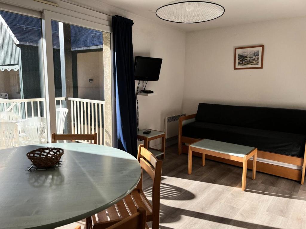 ein Wohnzimmer mit einem Tisch und einem Sofa in der Unterkunft Résidence Balcons Du Soleil 1 - T3/6pers BALCONS DU SOLEIL 63- Peyresourde MAE-9544 in Germ