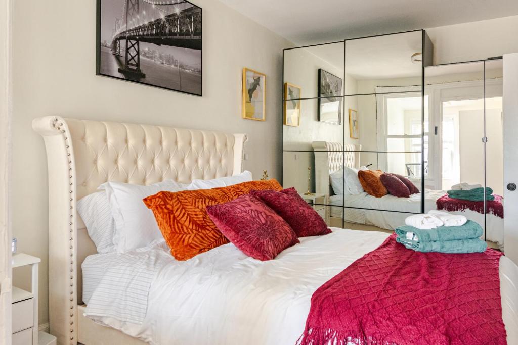 a bedroom with a large white bed with colorful pillows at Elegant 4BR & 4BA House in DC in Washington