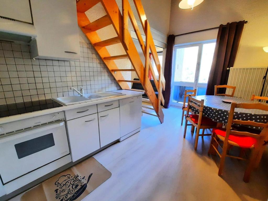 une cuisine avec un évier et une table avec des chaises dans l'établissement Résidence Jetay - Appartement avec mezzanine pour 6 personnes MAE-4624, aux Menuires