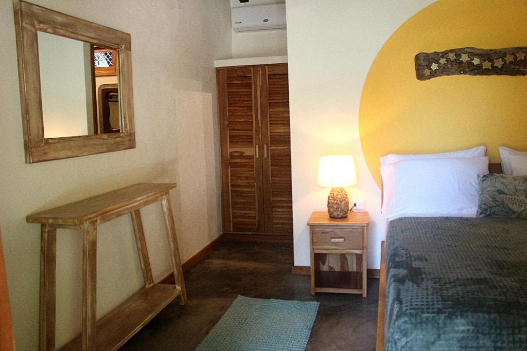 Postel nebo postele na pokoji v ubytování Tiki Lodge Hotel de Charme