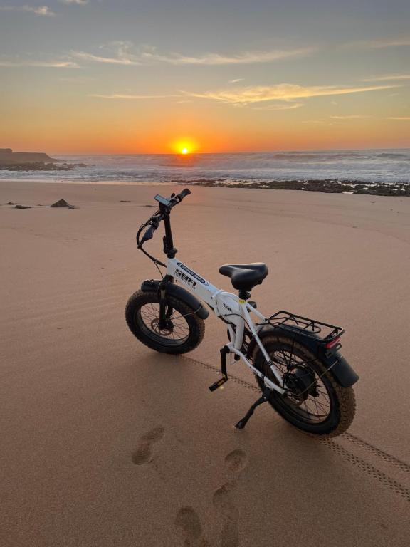 a bike parked on the beach at sunset at Villa La Falaise in Oualidia