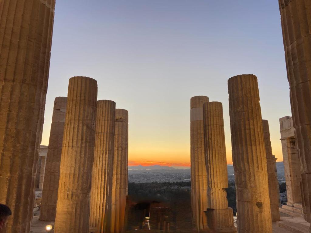 a view of the ruins of a city at sunset at Apeiron Acropolis Suites in Athens