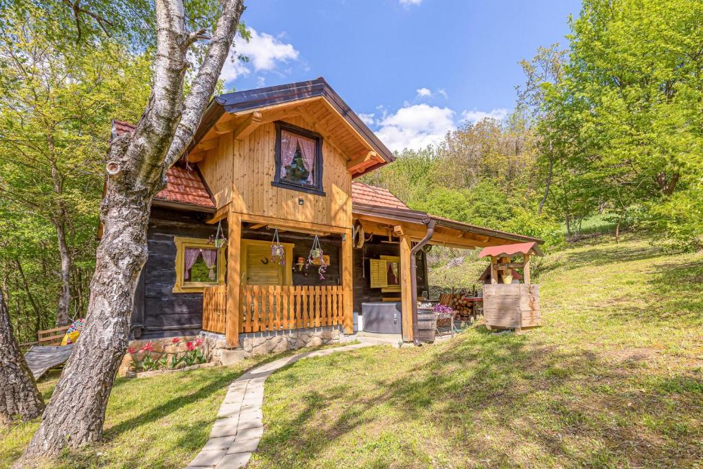 a cabin in the woods with a tree at Chalet Birchwood With Whirlpool and Sauna - Happy Rentals in Hum Breznički