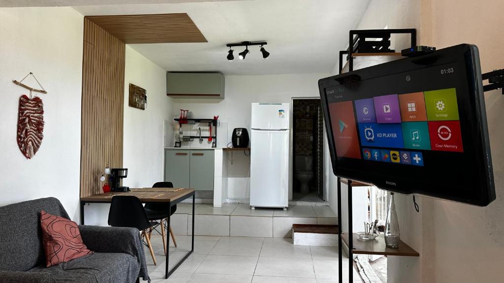 ein Wohnzimmer mit einem TV und einer Küche in der Unterkunft Casa da Floresta in Rio de Janeiro