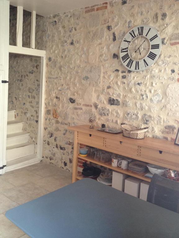 un mur en pierre avec une horloge sur un mur dans l'établissement Charmante Maison De Pêcheur, à Honfleur