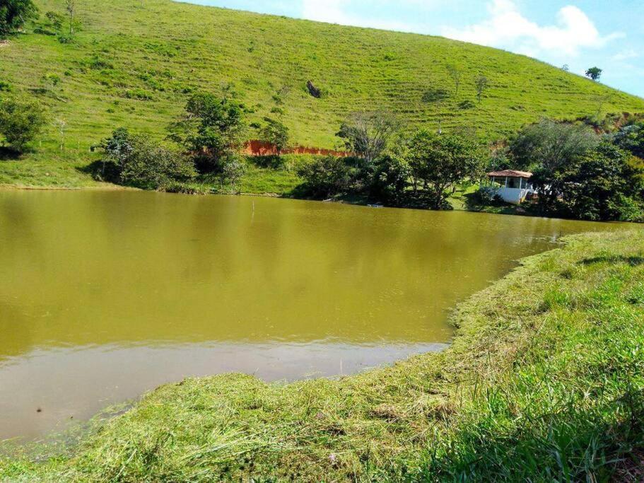 ein Hügel mit einem Teich und einem Haus darauf in der Unterkunft Casa no Sitio em São José do Barreiro in São José do Barreiro