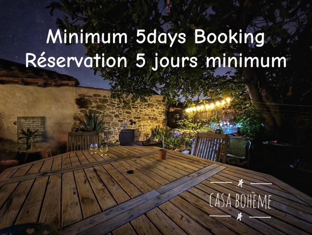 une table en bois devant un mur de briques dans l'établissement Casa Bohême, à Caunes-Minervois
