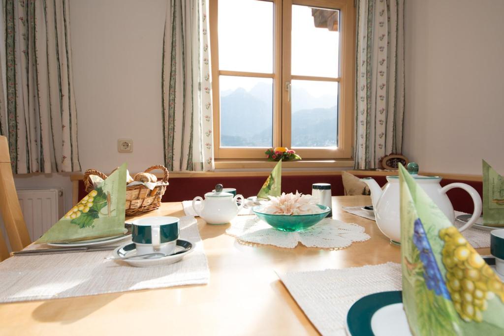 tavolo da pranzo con tavolo e piatti e ciotole di Bio-Bauernhof Einberghof a Pfarrwerfen
