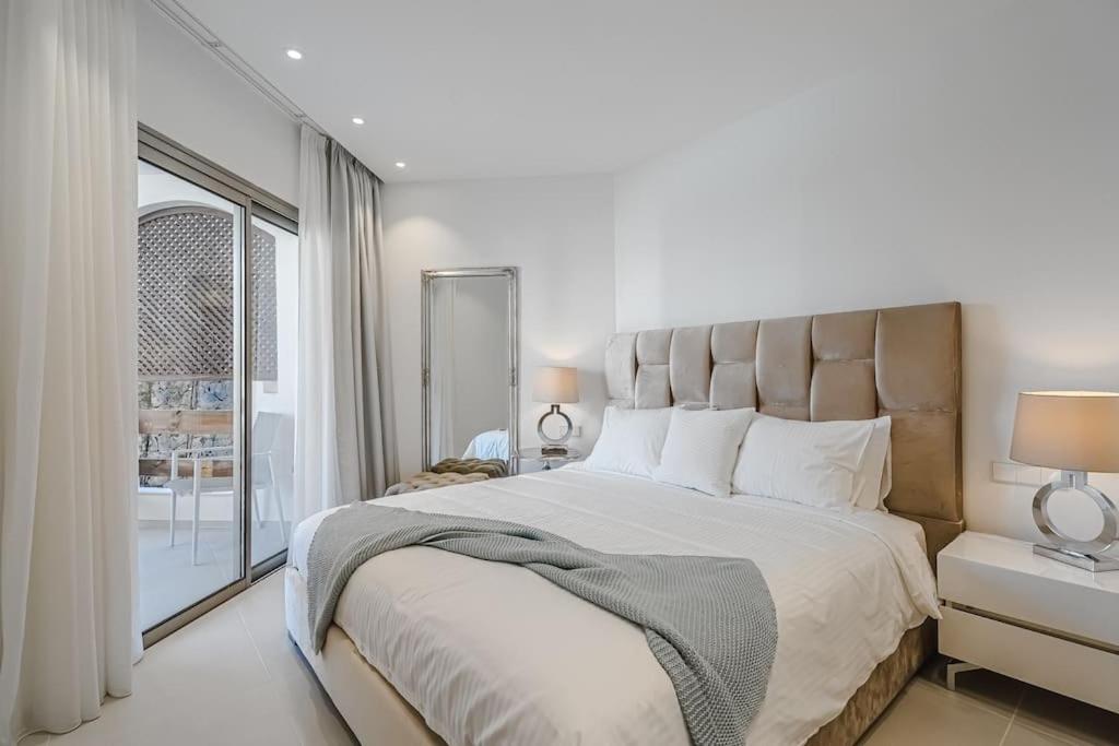 ein Schlafzimmer mit einem großen Bett mit einem großen Fenster in der Unterkunft Luxury 2 bedrooms apartment in Palm-Mar, Tenerife in Palm-mar