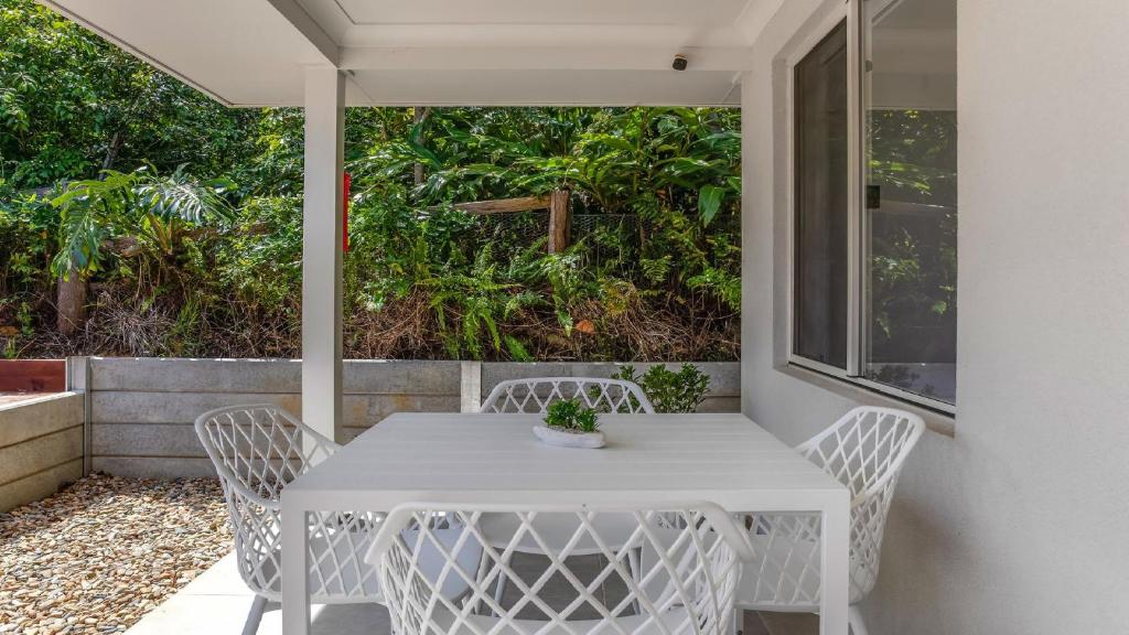 a white table and chairs on a patio at 'Coastal Harmony Cottage' by HolidayCo in Hardys Bay