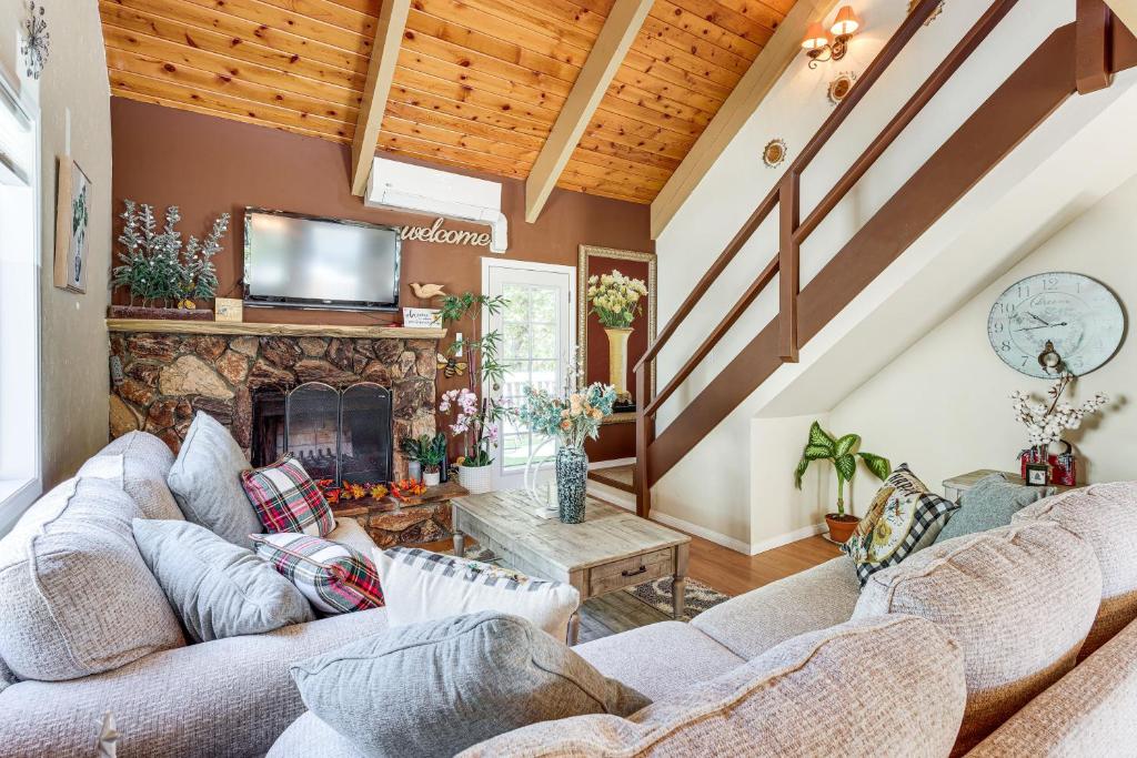 a living room with couches and a fireplace at Home with 2 Decks - 2 Mi to Lake Gregory Dog Park! in Crestline
