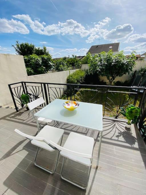 - une table et des chaises sur un balcon avec un bol dans l'établissement Maison proche Paris, Aéroport CDG, Stade de France, à Drancy