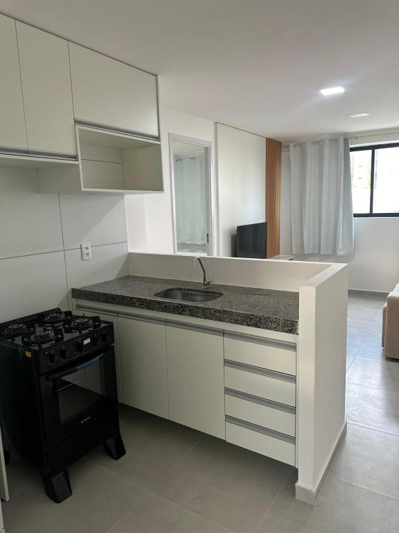a kitchen with a counter top and a stove top oven at Luar da Praia in Olinda