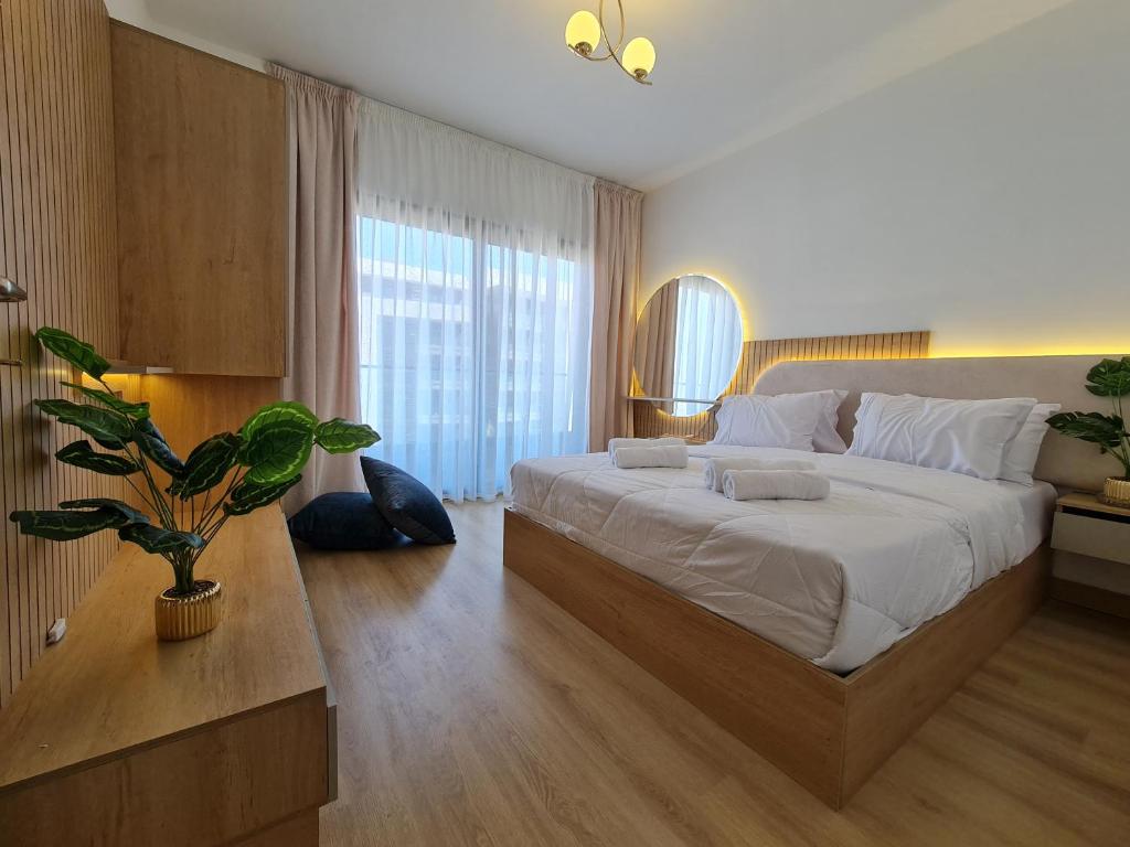 a bedroom with a large bed and a potted plant at Madinaty Elite Living Apartment in New cairo