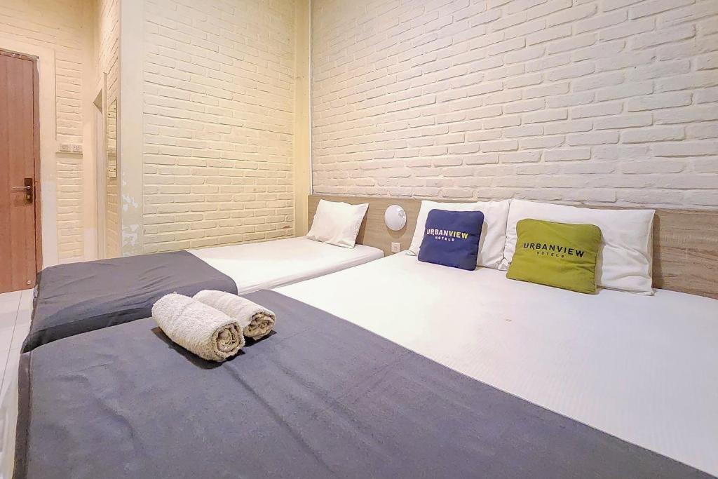 two beds sitting next to each other in a room at Urbanview Hotel Star Residence Puncak in Campaka