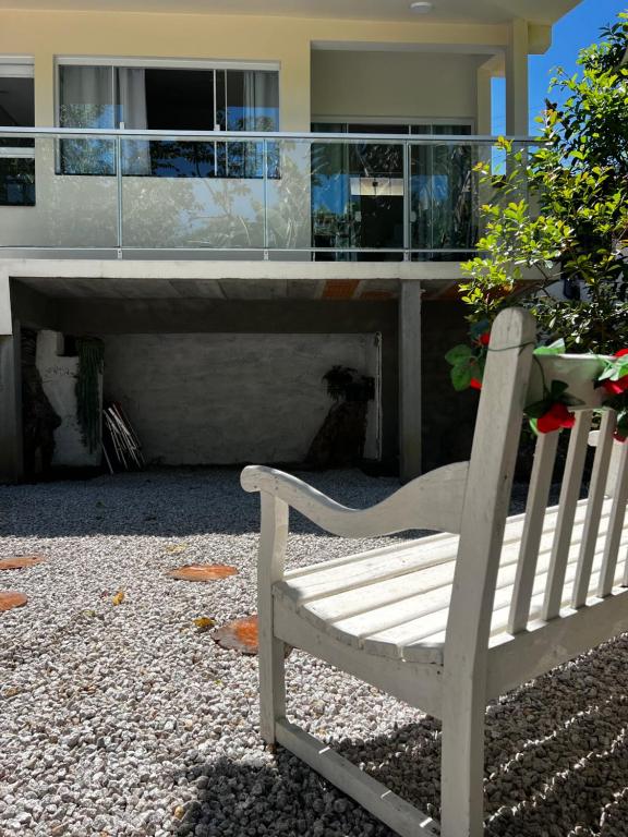 a white bench sitting in front of a house at Casa com banheira in Governador Celso Ramos