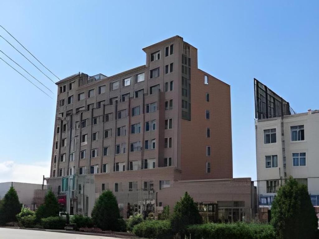 a large brick building on the side of a street at GreenTree Inn Zhangye Ganzhou Train Station Orthopaedic Hospital in Zhangye