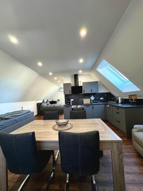a kitchen and living room with a wooden table and chairs at Glück Apartments (Europa-Park Rust) in Kappel-Grafenhausen